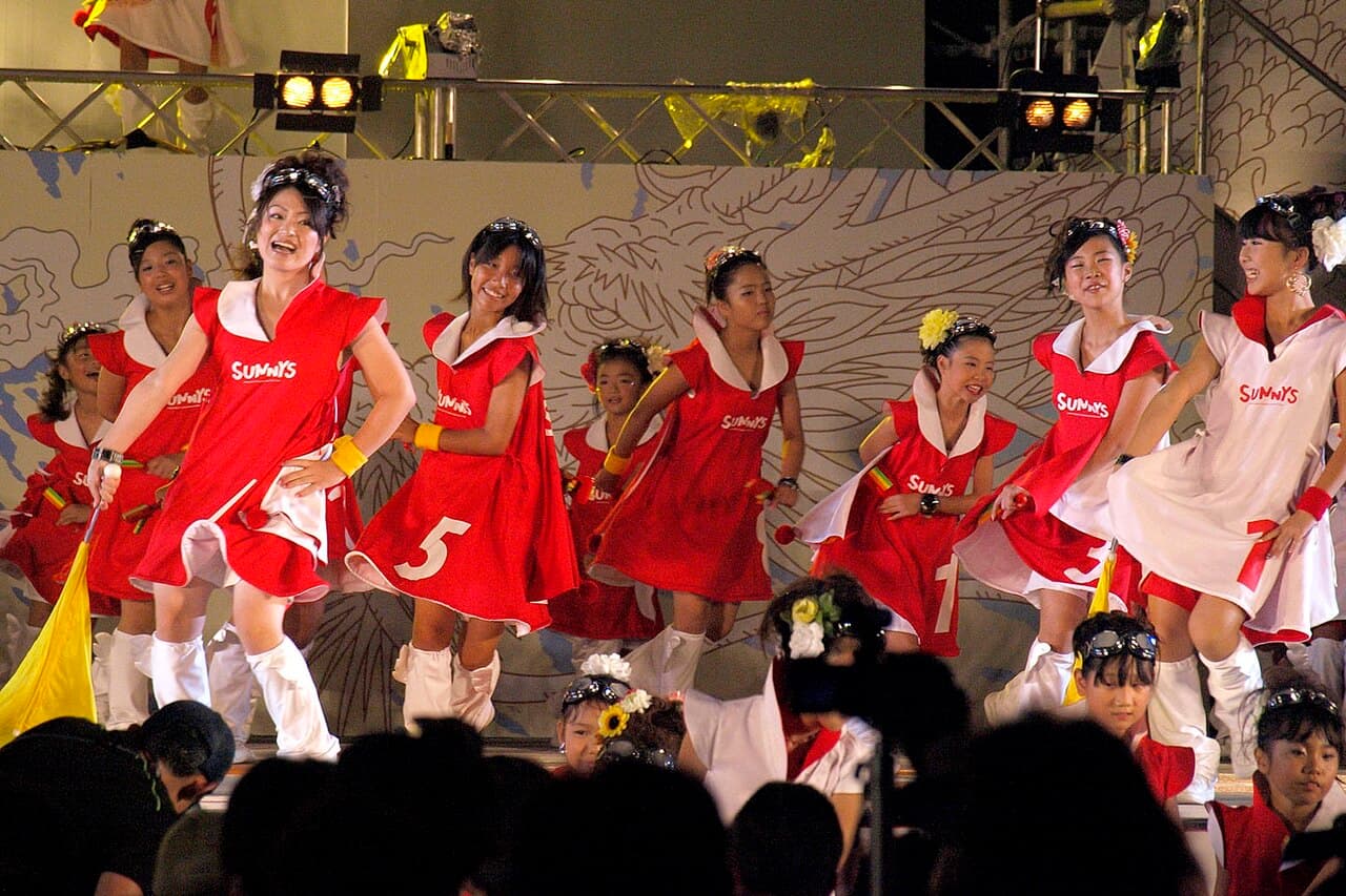 Yosakoi dancers in matching costumes performing with naruko clappers on a street in Kochi at the Yosakoi Festival