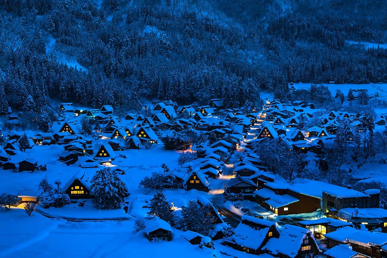 Shirakawa-go's snow-covered gassho-zukuri farmhouses lit up at night, seen from the village observatory, Gifu Prefecture