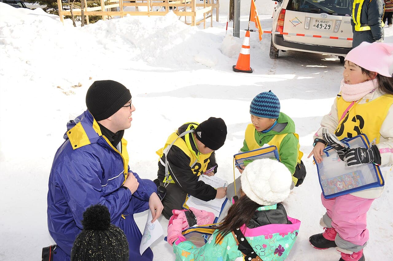 A large detailed snow sculpture at the Sapporo Snow Festival in Odori Park, with visitors in front