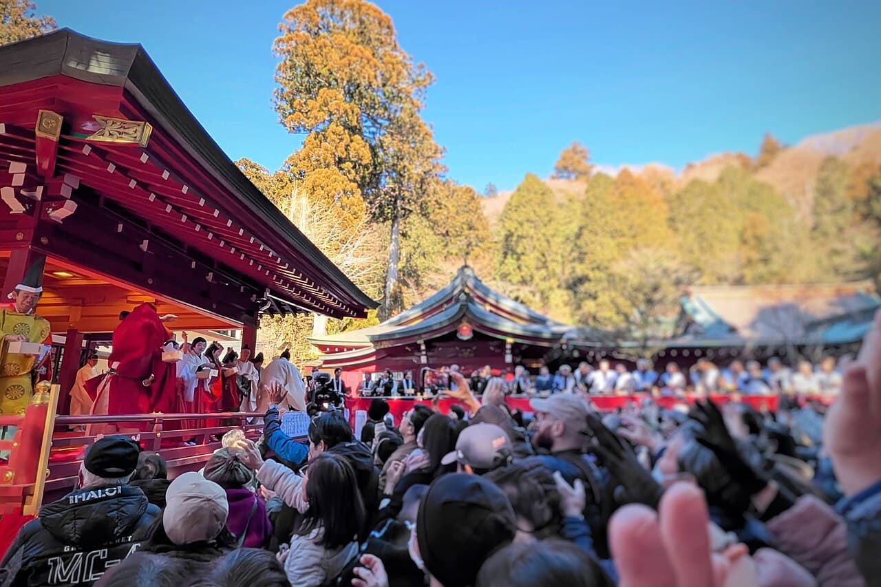 Participants throwing roasted soybeans during a mamemaki bean-throwing ceremony at a Setsubun festival