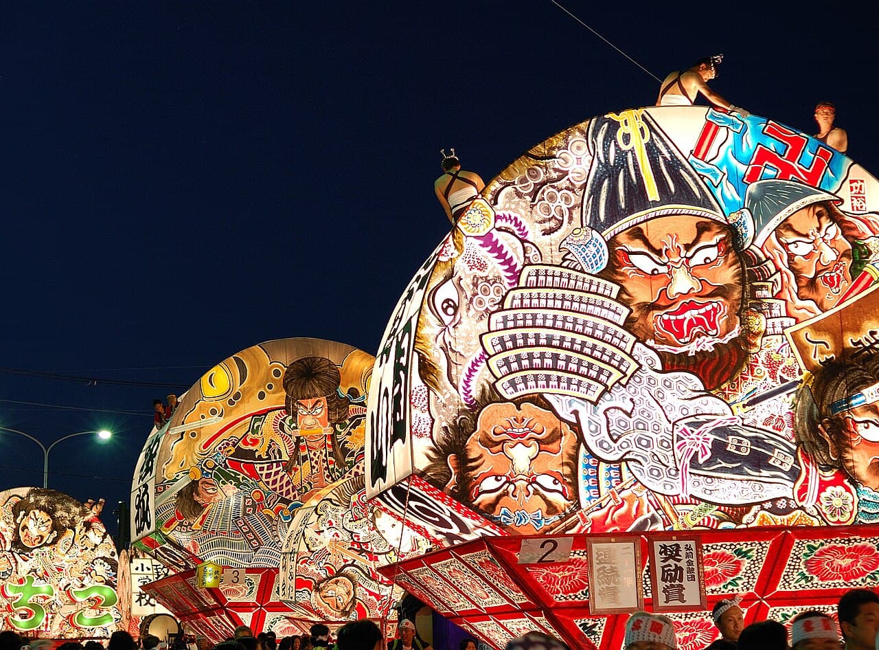 Fan-shaped Ōgi-Neputa floats lit up at night during the Hirosaki Neputa Festival
