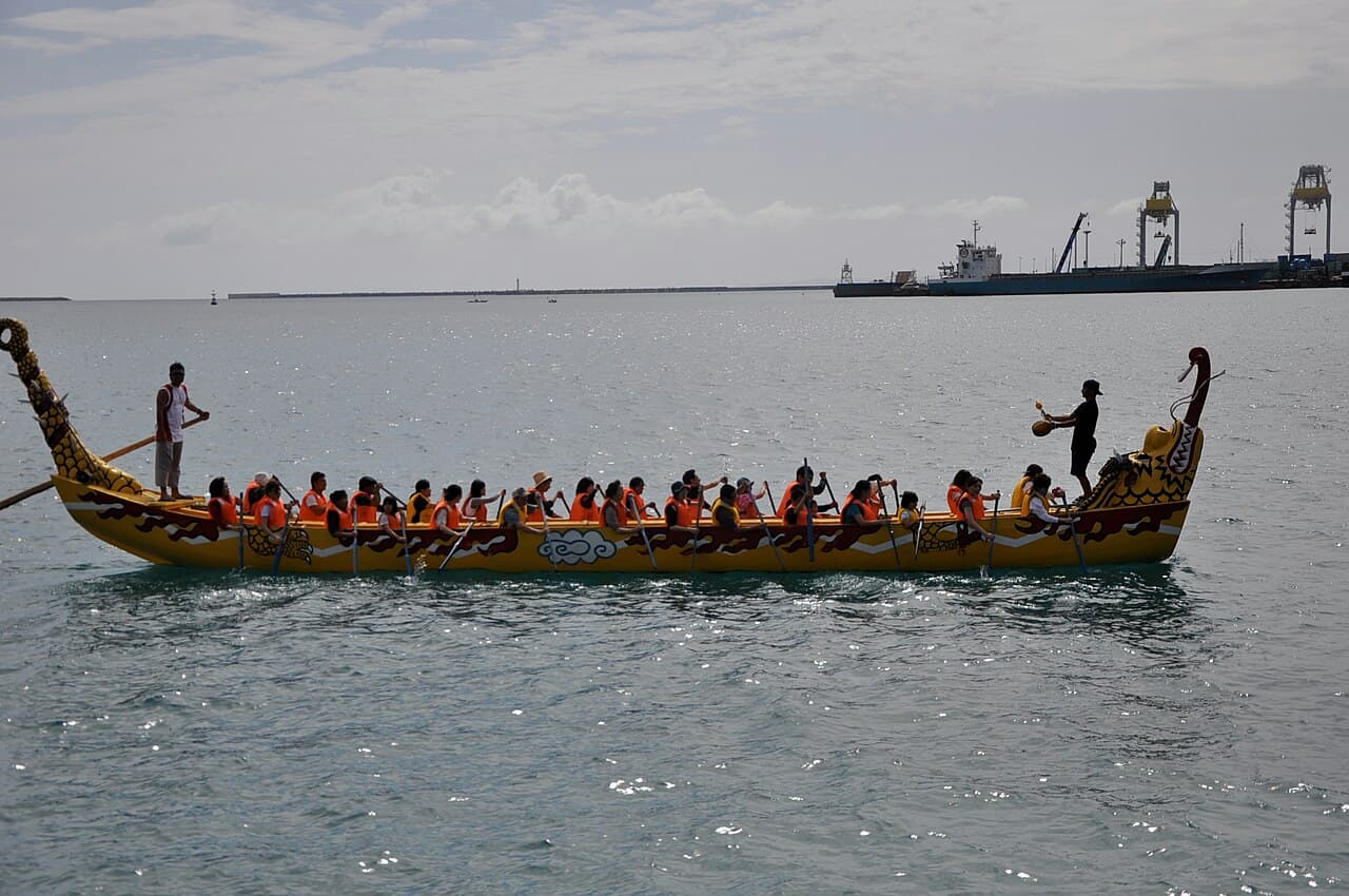 Teams paddling decorated dragon boats at the Naha Hari festival in Okinawa