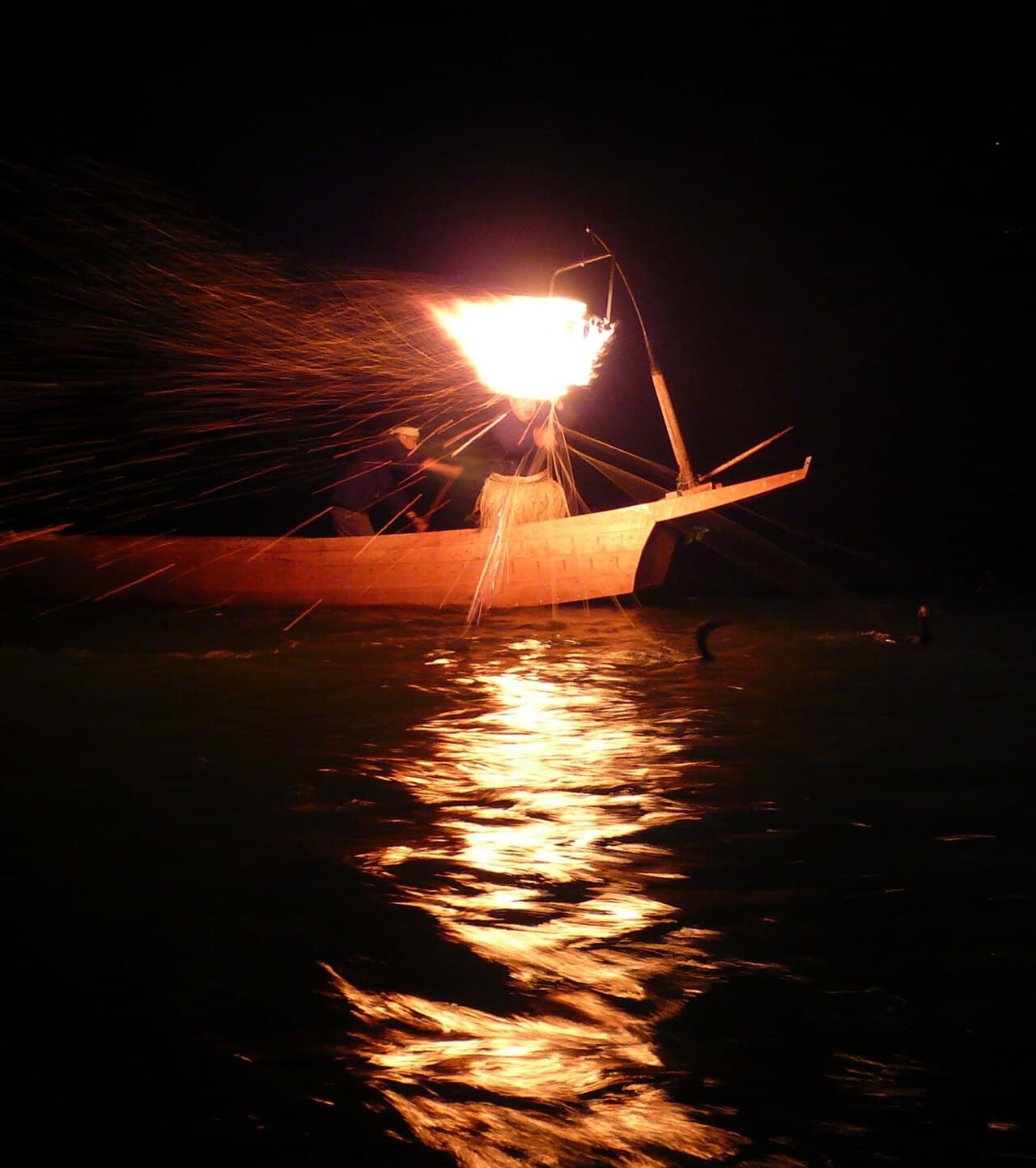 Torchlit cormorant fishing boat on the Nagara River at night in Gifu, Japan