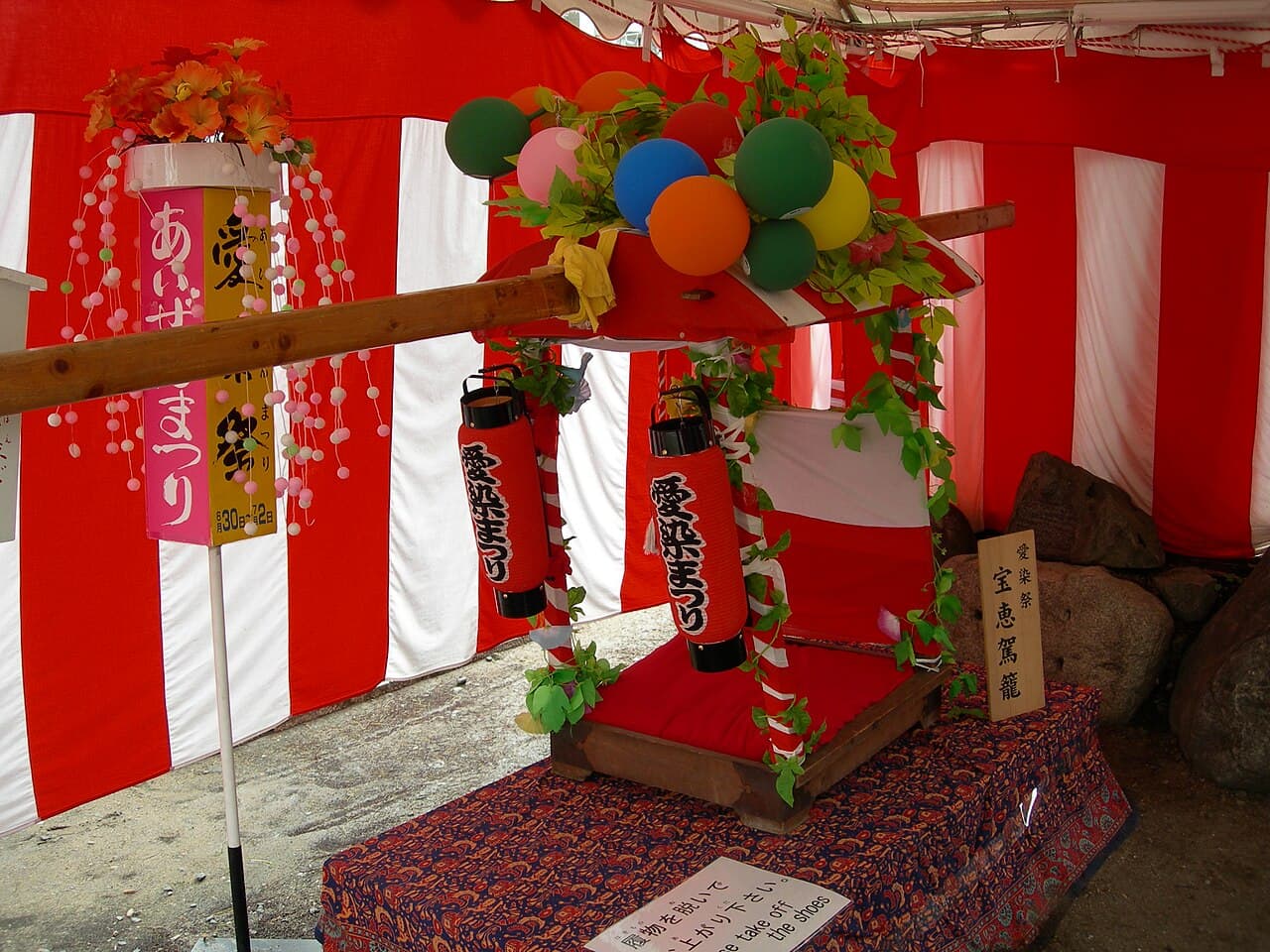 A red-and-white hoekago palanquin carried during Osaka's Aizen Matsuri