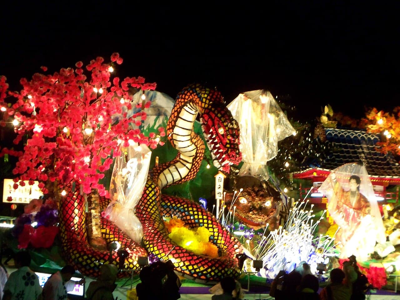 An illuminated ornate yatai float at night during the Shinjo Matsuri
