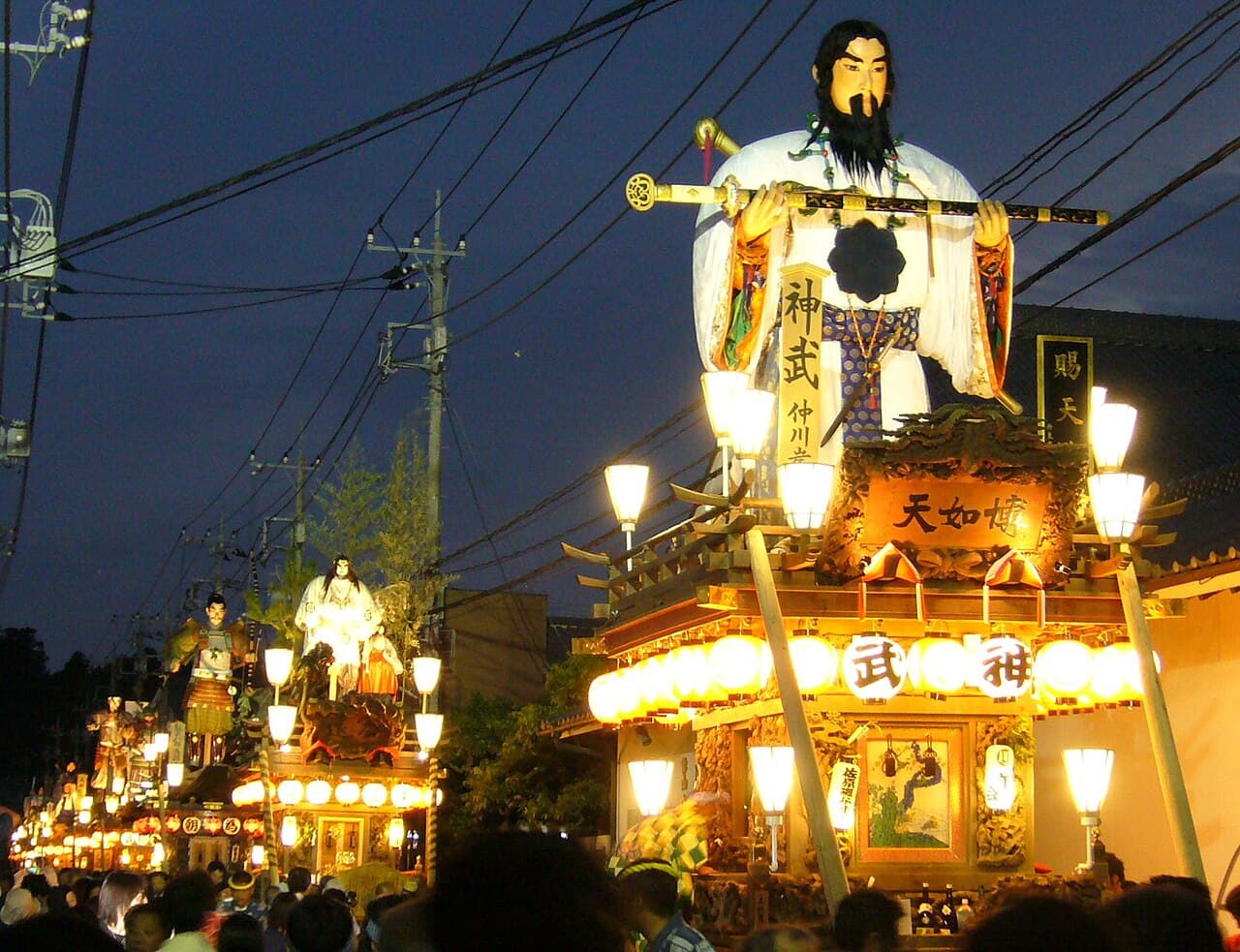 A line of tall wooden floats with giant dolls at the Sawara Grand Festival
