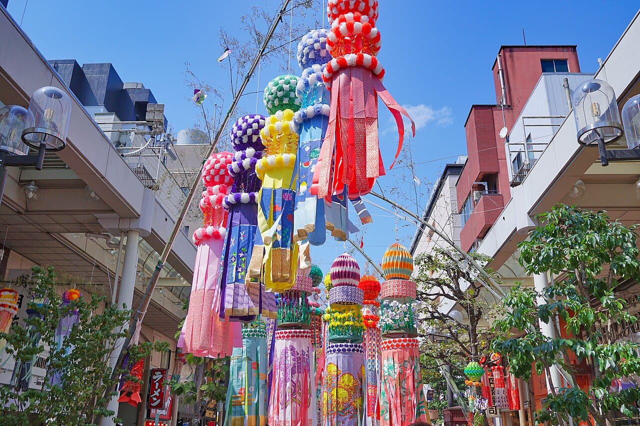 Long colourful washi-paper streamer decorations hanging from bamboo poles along a covered shopping arcade at the Sendai Tanabata Festival